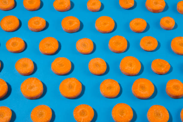 istock Sliced Carrot Ina Row on Blue Background 1140840635