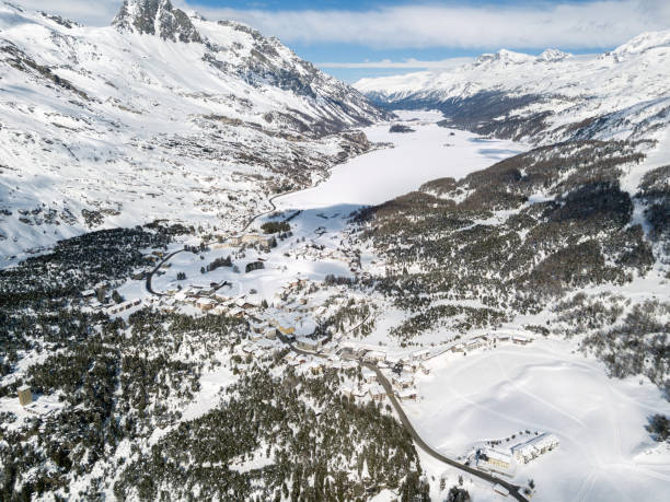Aerial view over the Engadin valley with St. Moritz and Maloja, Switzerland Aerial view by drone over the Engadin valley with ski resorts St. Moritz lakes and Maloja, Swiss Alps, Switzerland maloja region stock pictures, royalty-free photos & images
