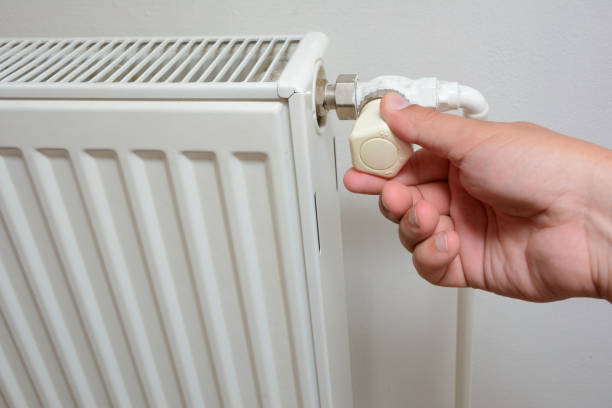 istock Hand adjusting the knob of heating radiator 1140851741