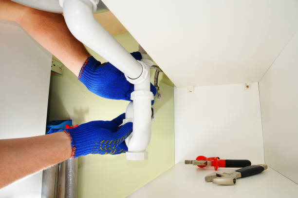 istock Plumber fixing the sink siphon in a kitchen. 1140851810