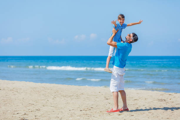 istock Father and son playing at beach together. 1140851825