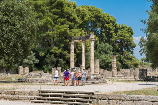 los turistas están visitando el monumento de filipeion en el yacimiento arqueológico de olimpia en grecia. la antigua olimpia es de los santuarios griegos antiguos más influyentes, ubicados en el peloponeso occidental, en ilia - sanctuaries fotografías e imágenes de stock