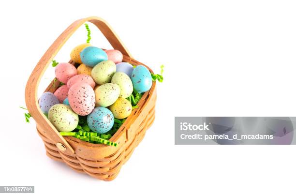 A Wooden Easter Basket Filled With Decorated Eggs Isolated On A White Background Stock Photo - Download Image Now