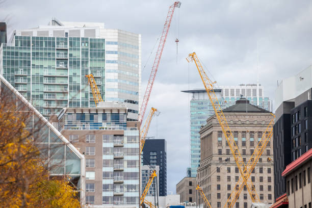 Picture of cranes, pipes, scaffoldings and other building devices in dowtown Montreal, the main business hub of Quebec, and one of the biggest of canada, surrounded by condos and skyscrapers.