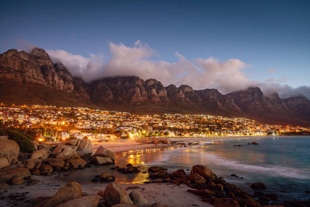 Camps Bay Atmospheric Twilight Cape Town South Africa Beautiful illuminated Camps Bay, Scenic view after sunset with beautiful cloudscape. Camps Bay, famous suburb of the city of Cape Town with white sandy beaches underneath the Table Mountain. Cape Town, South Africa cape town stock pictures, royalty-free photos & images