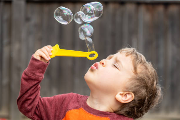 трехлетний мальчик дует пузыри - 2 3 years toddler bubble wand child стоковые фото и изображения
