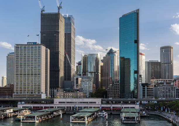 Part of Ferry terminal and Circular Quay Railway station, Sydney Australia. Sydney, Australia - February 12, 2019: Western Part of ferry terminal and Circular Quay Railway Station plus skyline in back. Highrises under construction with cranes. Evening shot with light blue sky. ferry terminal audio stock pictures, royalty-free photos & images