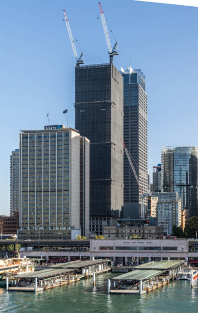 Part of Ferry terminal and Circular Quay Railway station, Sydney Australia. Sydney, Australia - February 12, 2019: Part of ferry terminal and Circular Quay Railway Station plus skyline in back. Highrises under construction with cranes. Evening shot with light blue sky. ferry terminal audio stock pictures, royalty-free photos & images