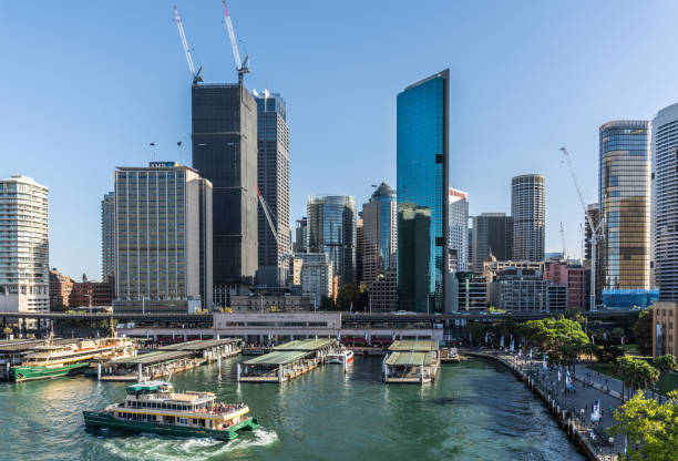 Ferry terminal and Circular Quay Railway station, Sydney Australia. Sydney, Australia - February 12, 2019: Western side of ferry terminal and Circular Quay Railway Station plus skyline in back. Highrises under construction with cranes. Evening shot with light blue sky. ferry terminal audio stock pictures, royalty-free photos & images