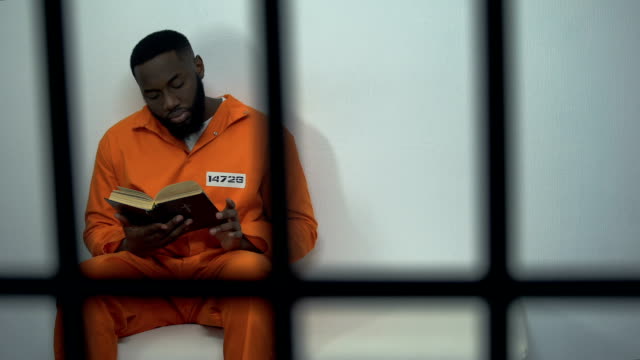 African-american prisoner reading holy bible, convicted sinner, religion