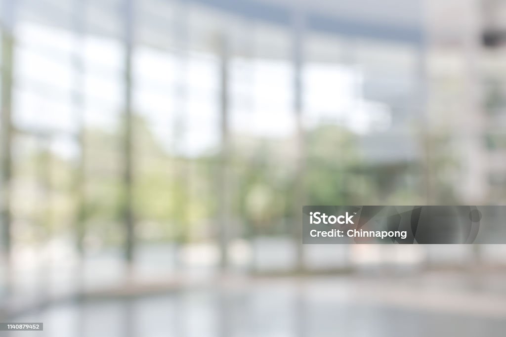 Office building business lobby blur background with blurry glass window transparent wall interior view inside empty entrance hall Blur background interior view looking out toward to empty office lobby and entrance doors and glass curtain wall Backgrounds Stock Photo