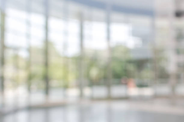 Office building business lobby blur background with blurry glass window transparent wall interior view inside empty entrance hall Blur background interior view looking out toward to empty office lobby and entrance doors and glass curtain wall corridor photos stock pictures, royalty-free photos & images