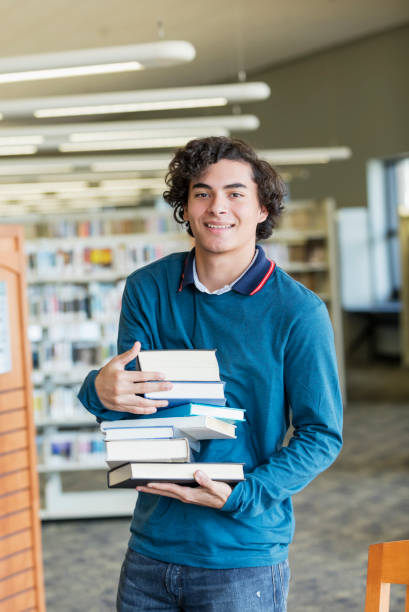istock Hispanic high school student carrying stack of books 1140883215