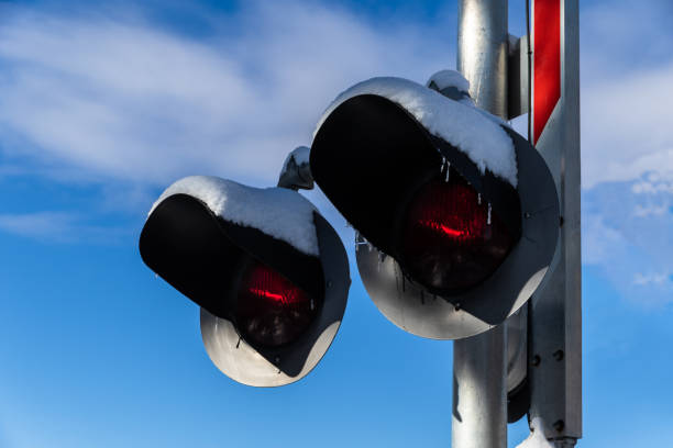 istock Railroad warning signal, covered with snow. Blue sky and clouds in background. 1140886547