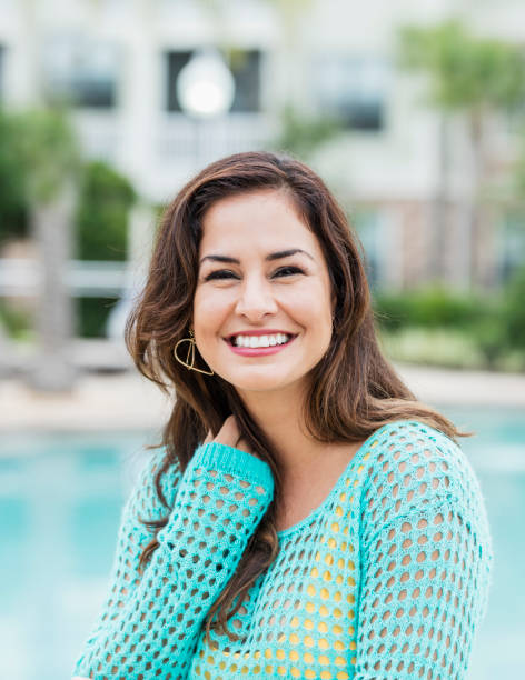 istock Hispanic woman smiling by swimming pool 1140887820