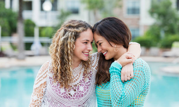 istock Hispanic sisters smiling by swimming pool 1140887836
