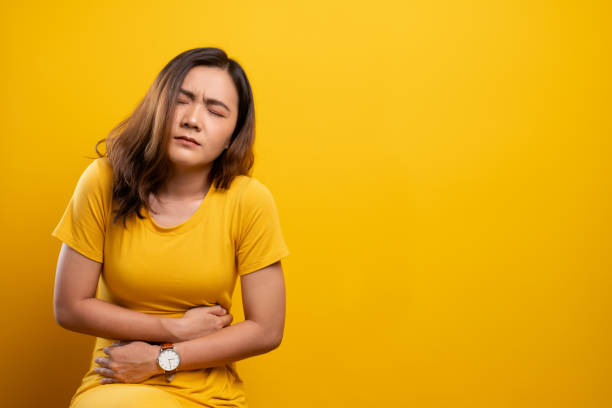 istock Woman has stomachache isolated over yellow background 1140891126