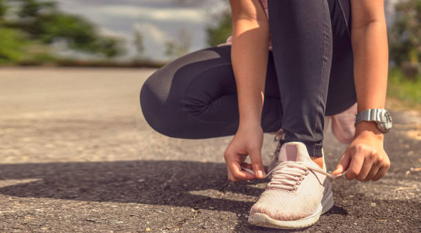 istock Female hands tying shoelace on running shoes before practice.Runner getting ready for training. Sport active lifestyle concept.Close-up.Horizontal photo banner for website header design 1140893035