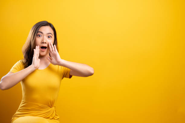 istock Woman make gossip gesture isolated over yellow background 1140893728