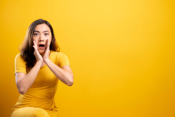 istock Woman make gossip gesture isolated over yellow background 1140893902