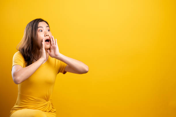 istock Woman make gossip gesture isolated over yellow background 1140893984
