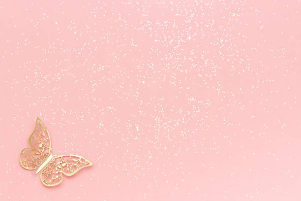Sparkles glitter and gold tracery butterfly on pink pastel trendy background. Festive background, template stock photo