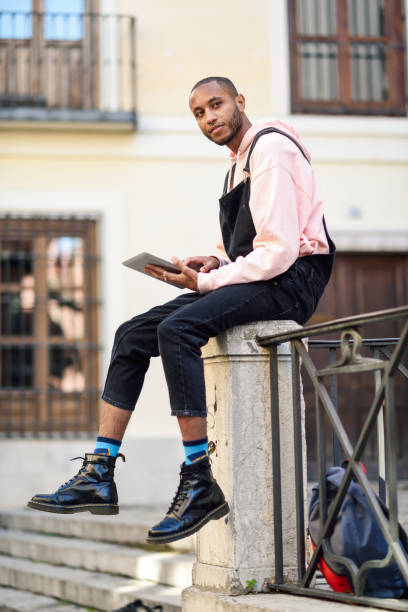 istock Young black man using digital tablet in urban background. 1140901395