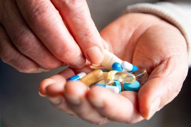 istock Colored pills in senior woman hands 1140904542