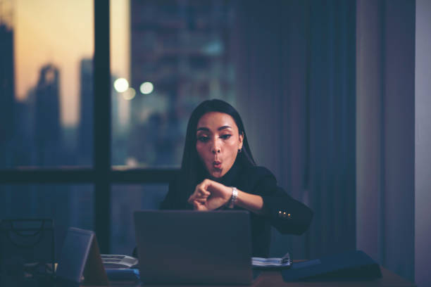 tired woman at home office looking at her watch - waiting women clock boredom imagens e fotografias de stock