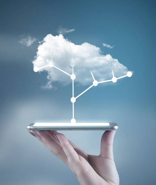 Hand holding a smartphone with a circuit board tree and a cloud above