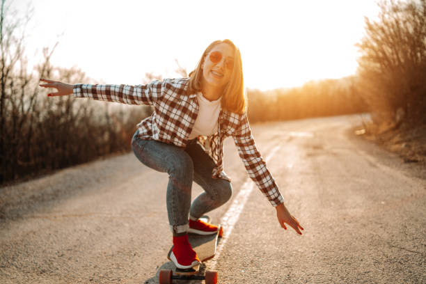 istock Young woman skateboarding on empty road 1140916856