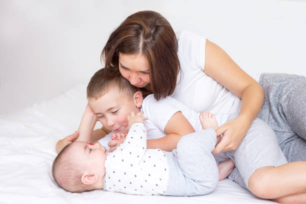 istock Young mom with her two sons playing on a bed 1140918067