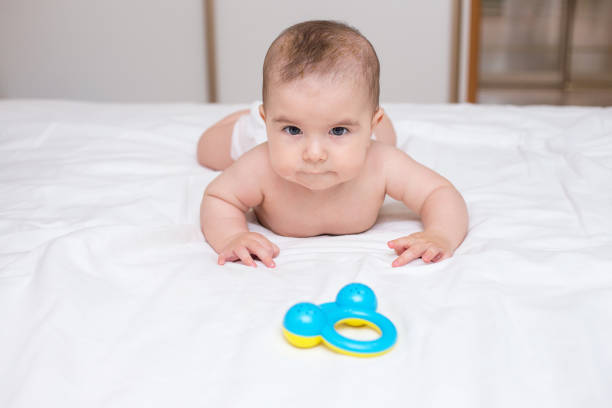 cute baby boy is playing with a toy rattle