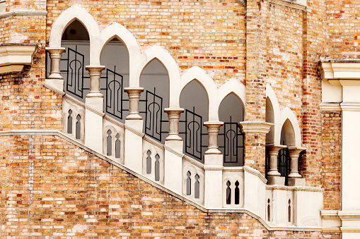 Lancet windows with staircase, architectural detail of old colonial style building Bangunan Sultan Abdul Samad, Sultan Abdul Samad Building. Kuala Lumpur, Malaysia.