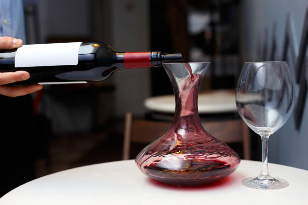 sommelier gießt wein in einen dekanter - decanter wine wineglass red wine stock-fotos und bilder