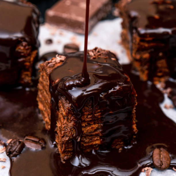 Liquid chocolate flows on top of the cake. Close-up.