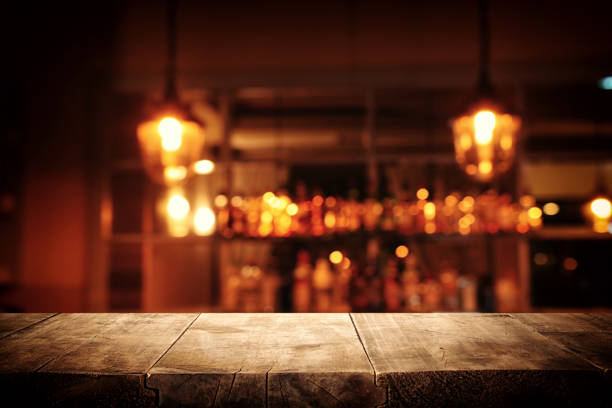 istock Image of wooden table in front of abstract blurred restaurant lights background 1140934708
