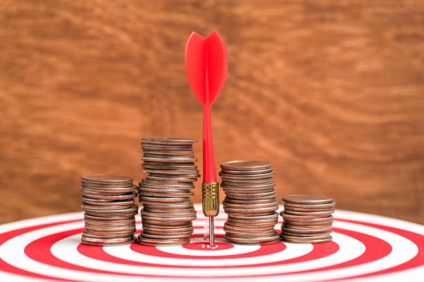istock Close-Up Of Red Dart Amidst Coins On Target 1140936594