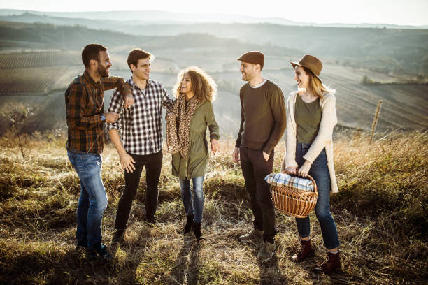 istock Group of happy friends talking while going on picnic in autumn day. 1140936615