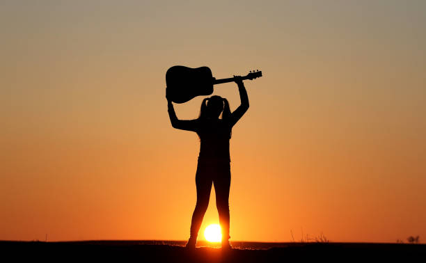 istock Silhouette of a guitar player at sunset 1140937012
