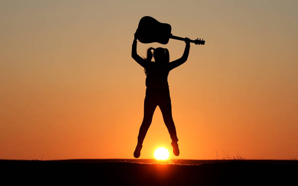 istock Silhouette of a guitar player at sunset 1140937133