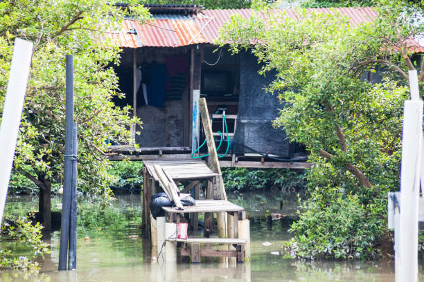 istock Wooden house by the river side view indicating poverty 1140939483