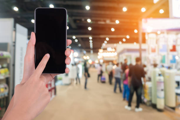 istock Cropped Hands Using Blank Mobile Phone In Shopping Mall 1140940115