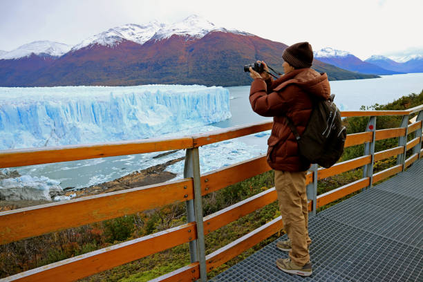 hombre disparando fotos del glaciar perito moreno desde el malecón en el parque nacional los glaciares, el calafate, patagonia, argentina, sudamérica - turismo argentina fotografías e imágenes de stock