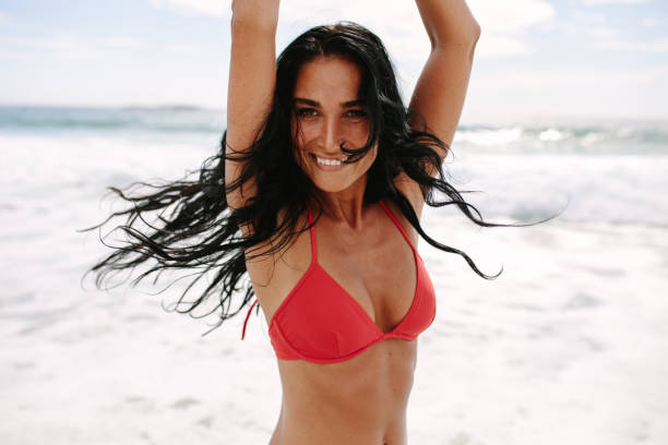 joyous женщина наслаждаясь на пляже - swimwear people fashion model leisure activity стоковые фото и изображения