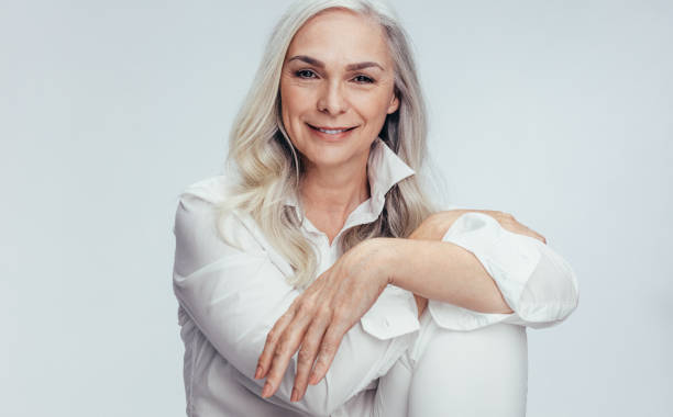 istock Beautiful mature woman sitting over white background 1140945202