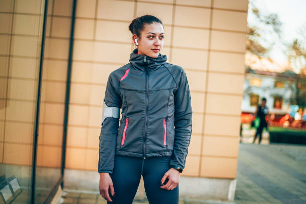 Portrait of a smiling young woman in sports wear having rest outdoors