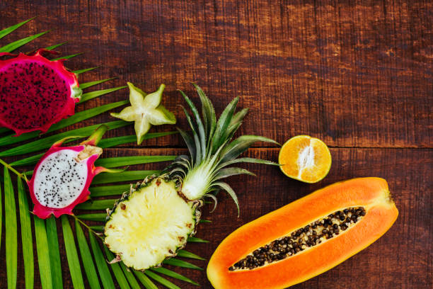 istock Tropical fruit on black wooden background 1140951305