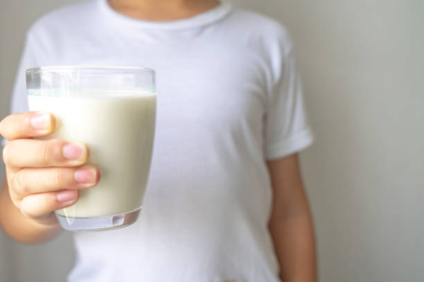 Little boy holding milk glass for drink stock photo