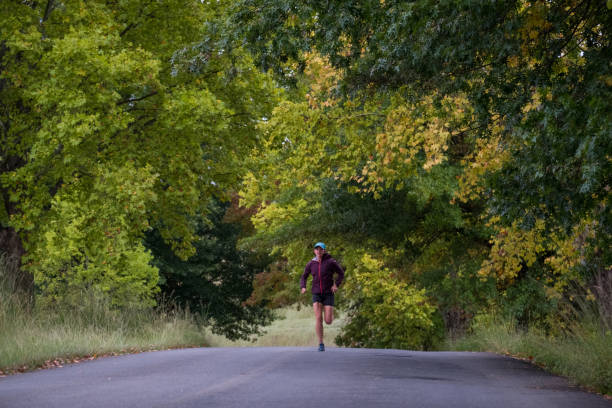 istock Female athlete running in along the road 1140957143